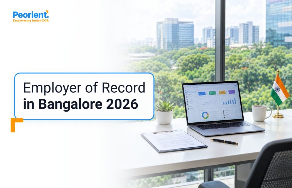 Glass-walled Bengaluru tech park office desk with laptop and employment agreement, for hiring in Bangalore through an EOR